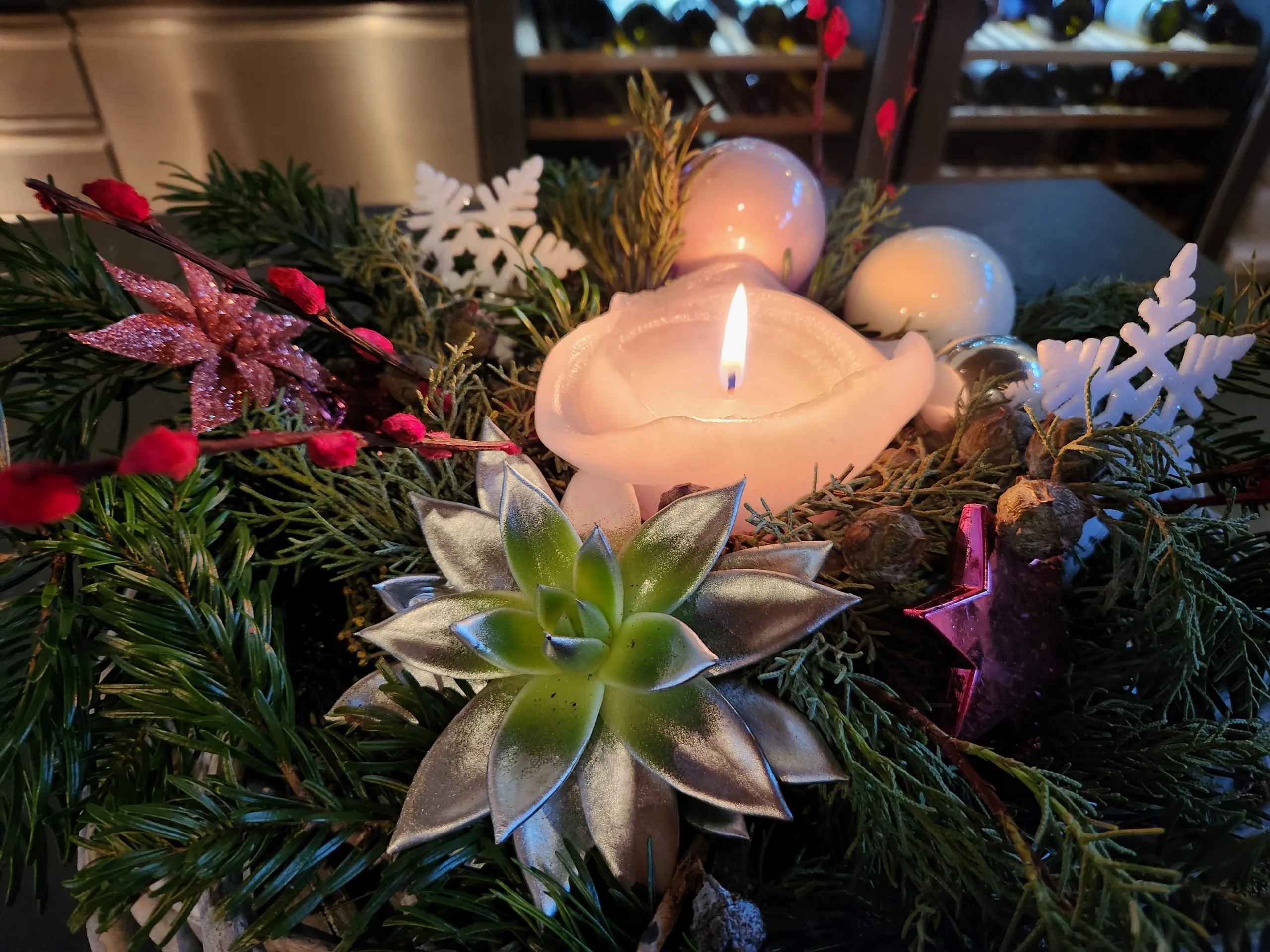 Adventsgesteck mit Kerze, Tannenzweigen und Sukkulenten